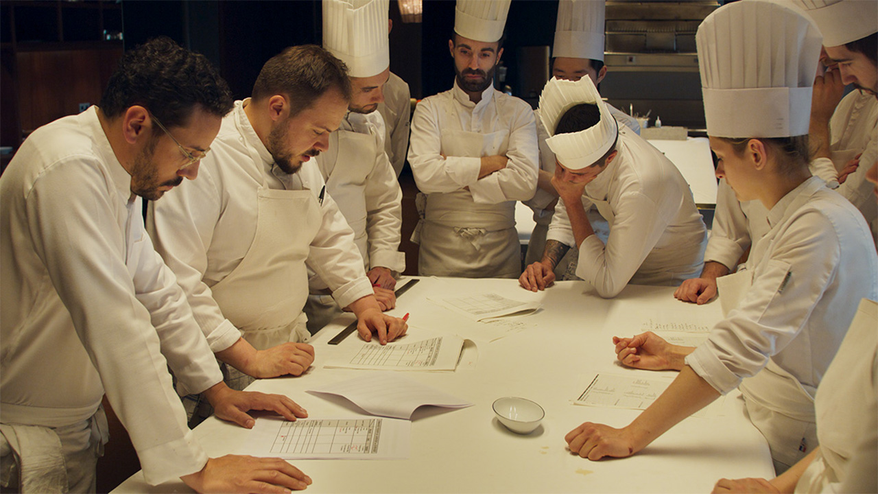 many chefs gathered around a table in discussion